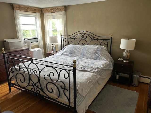 bedroom with a textured ceiling and wood-type flooring