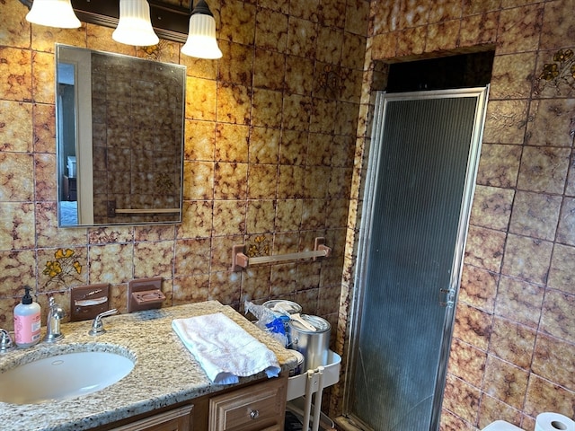 bathroom featuring vanity and tile walls