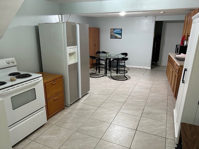 kitchen featuring white appliances and light tile floors