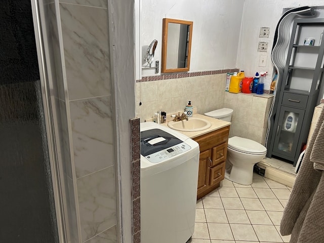 bathroom featuring washer / clothes dryer, tile floors, tile walls, tasteful backsplash, and toilet