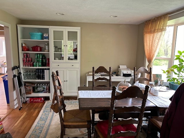 dining room with wood-type flooring and a textured ceiling