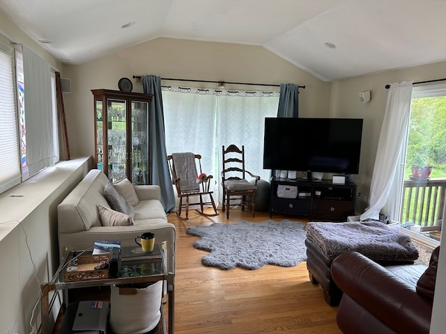 living room featuring lofted ceiling and hardwood / wood-style flooring