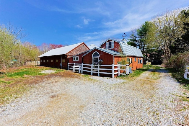 view of front of home featuring a barn, an outbuilding, metal roof, and a gambrel roof