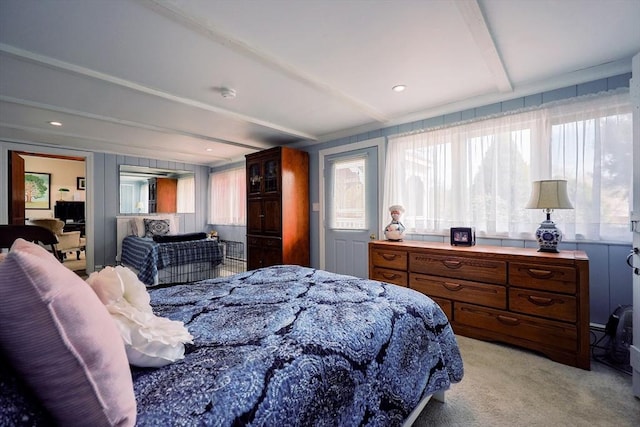 bedroom with beamed ceiling and light carpet
