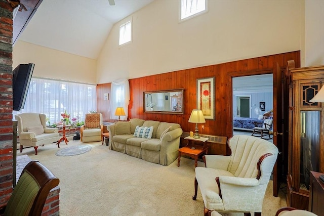 living area with wooden walls, high vaulted ceiling, and carpet flooring