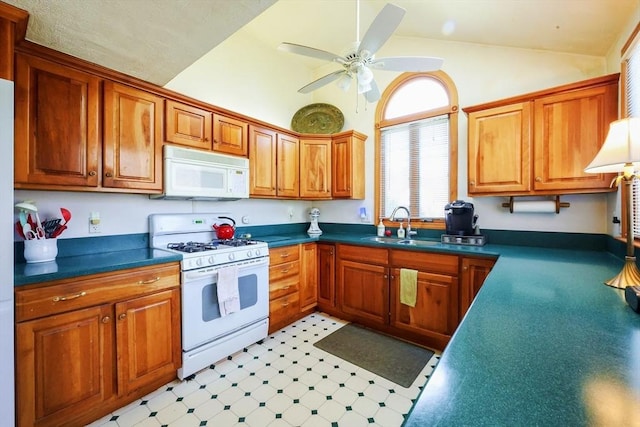 kitchen featuring dark countertops, white appliances, light floors, ceiling fan, and a sink