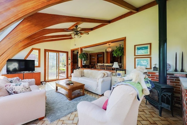 living room with ceiling fan, lofted ceiling with beams, and a wood stove