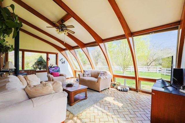 living area featuring ceiling fan and lofted ceiling with beams
