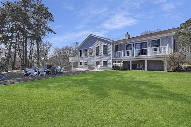 back of house featuring a yard, a chimney, and a patio area