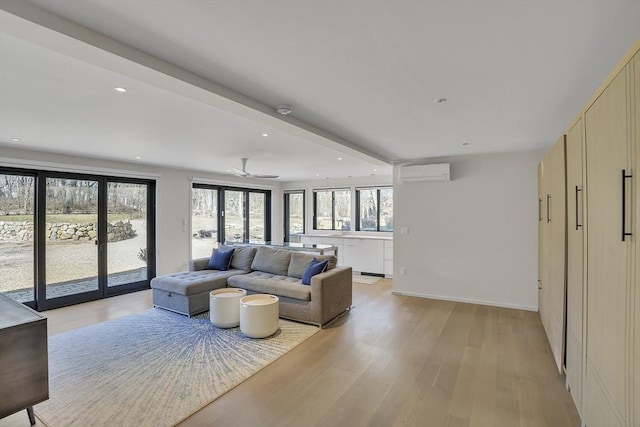 living area featuring recessed lighting, light wood-style flooring, baseboards, and a wall mounted air conditioner