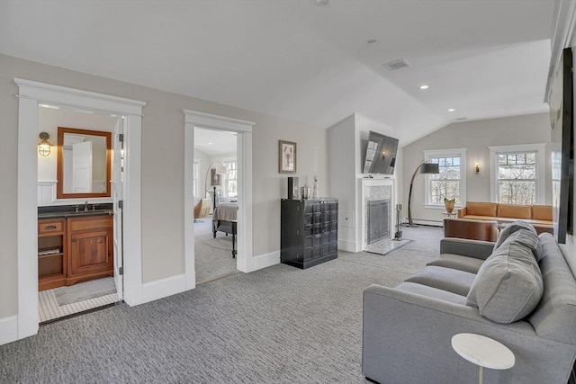 living area featuring baseboards, visible vents, a fireplace with flush hearth, vaulted ceiling, and carpet flooring