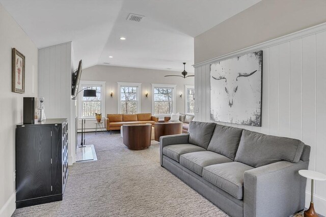 carpeted living room featuring lofted ceiling, recessed lighting, visible vents, baseboard heating, and ceiling fan