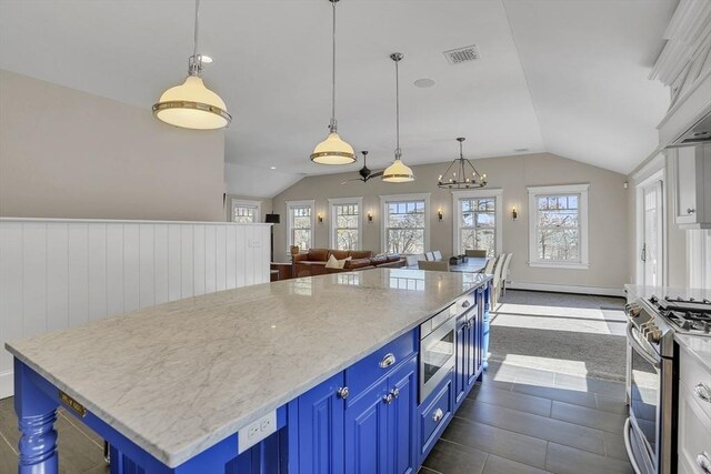 kitchen with blue cabinets, lofted ceiling, visible vents, and appliances with stainless steel finishes