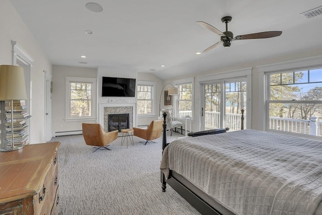 carpeted bedroom with access to exterior, a baseboard radiator, visible vents, a large fireplace, and vaulted ceiling