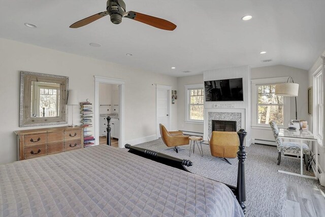 bedroom featuring lofted ceiling, recessed lighting, a large fireplace, visible vents, and baseboard heating