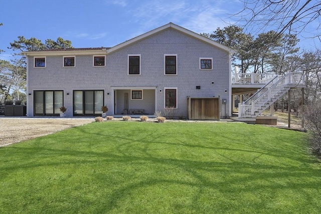 back of house featuring a lawn, a deck, and stairs