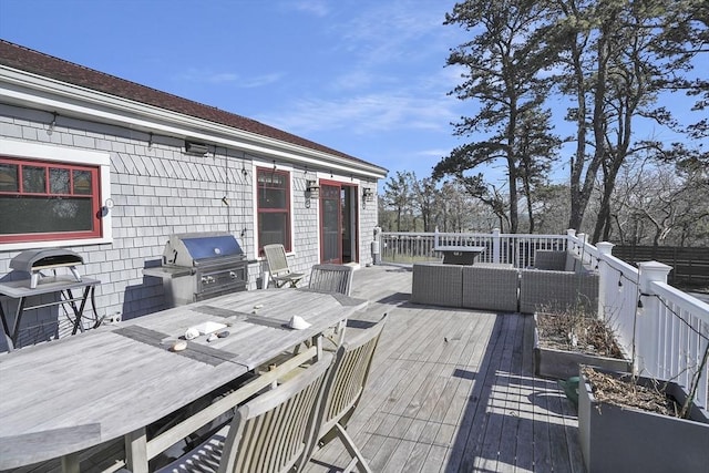 wooden terrace with outdoor dining space, a grill, and an outdoor living space