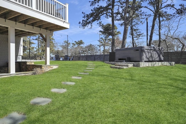 view of yard with a jacuzzi and fence