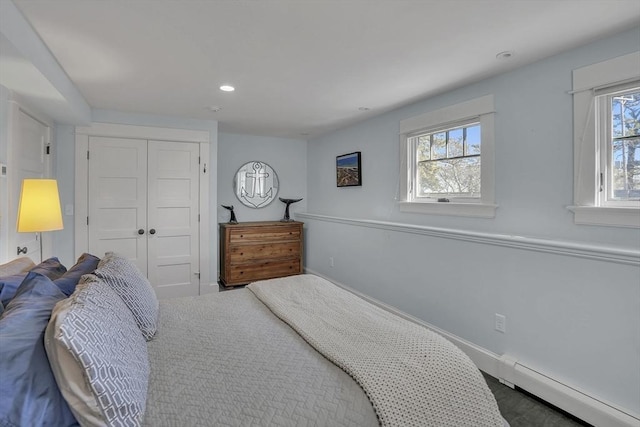 bedroom with a closet, a baseboard radiator, and recessed lighting