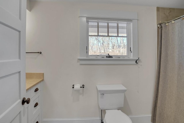 full bath with a shower with shower curtain, vanity, toilet, and baseboards