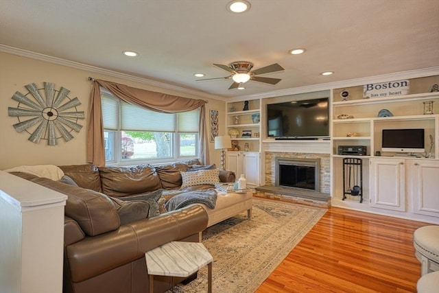 living room featuring recessed lighting, a ceiling fan, ornamental molding, and light wood-style floors