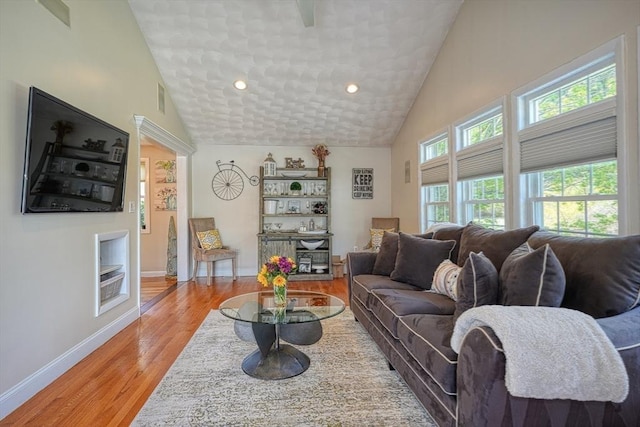 living room featuring visible vents, baseboards, high vaulted ceiling, recessed lighting, and light wood finished floors