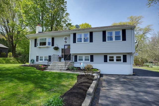 bi-level home featuring a front lawn and a chimney