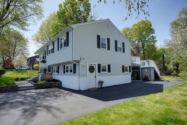 view of front of house with stairs and a front lawn
