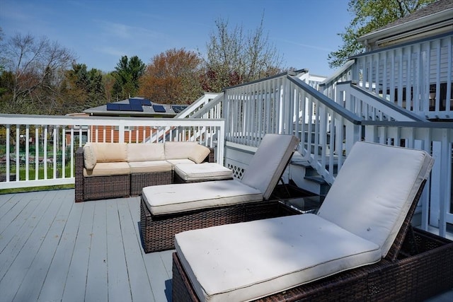 wooden terrace with an outdoor living space and stairway