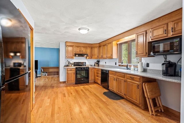 24 Floyd Ave, Tewksbury, MA 01876 - kitchen featuring black appliances, a sink, light countertops, and light wood-style floors