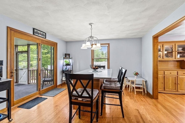 24 Floyd Ave, Tewksbury, MA 01876 - dining room with healthy amount of natural light, light wood-type flooring, a chandelier, a textured ceiling, and baseboards