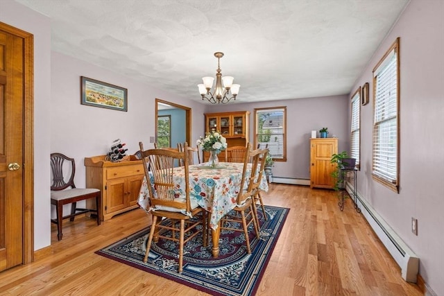 24 Floyd Ave, Tewksbury, MA 01876 - dining space with a baseboard heating unit, a chandelier, and light wood-style floors