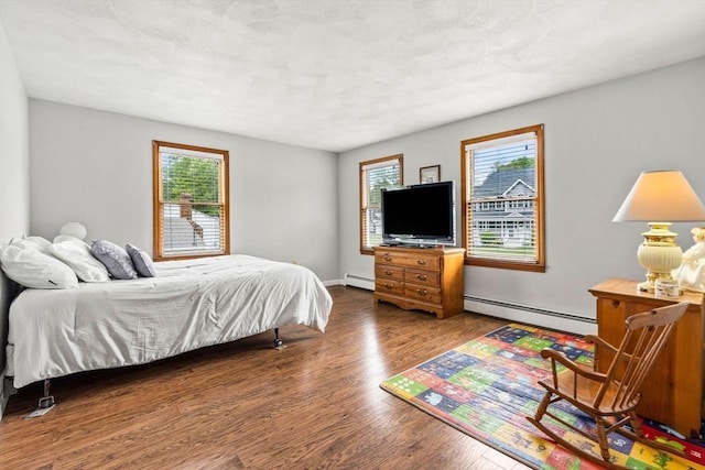 24 Floyd Ave, Tewksbury, MA 01876 - bedroom with a baseboard heating unit, wood finished floors, and baseboards