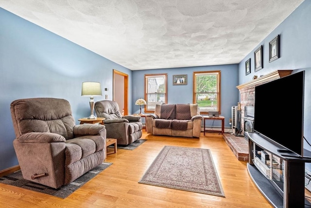 24 Floyd Ave, Tewksbury, MA 01876 - living room with light wood-type flooring, a fireplace, and baseboard heating