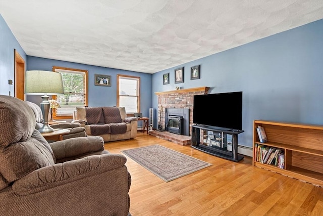 24 Floyd Ave, Tewksbury, MA 01876 - living room with wood finished floors, a fireplace, and baseboard heating