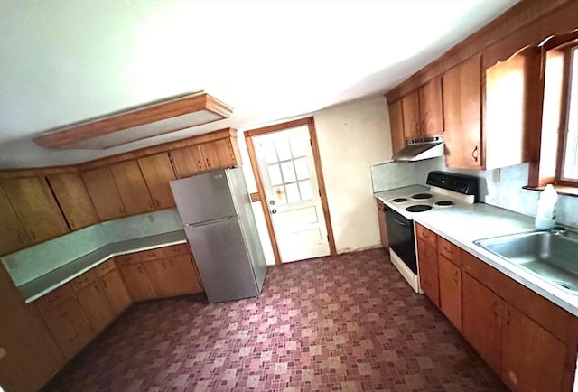 7 Lake Shore Dr, Georgetown, MA 01833 - kitchen with electric range, freestanding refrigerator, under cabinet range hood, and brown cabinetry