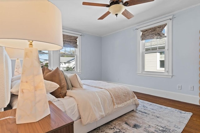bedroom with crown molding, baseboards, ceiling fan, and wood finished floors