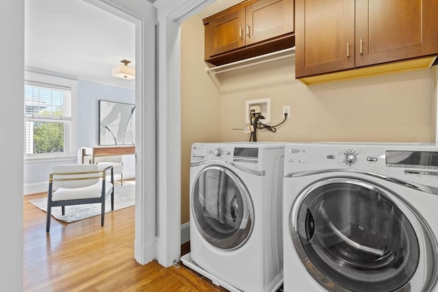 laundry area with light wood-style floors, cabinet space, independent washer and dryer, and baseboards