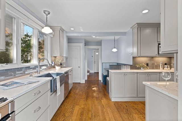 kitchen with decorative backsplash, a sink, and dishwasher