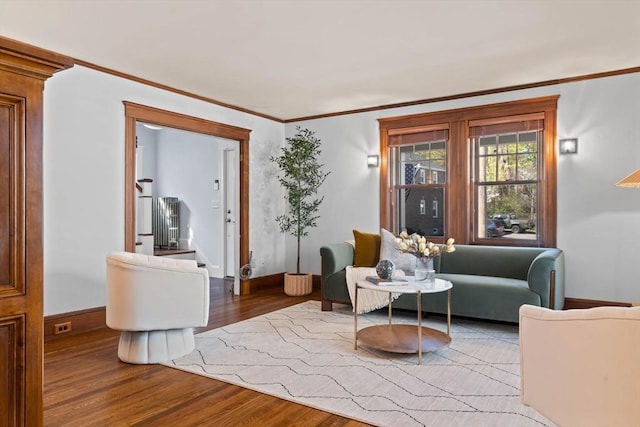 living area featuring baseboards, ornamental molding, and wood finished floors