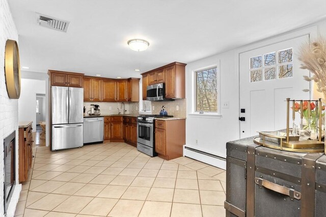 kitchen with visible vents, appliances with stainless steel finishes, light tile patterned flooring, decorative backsplash, and baseboard heating