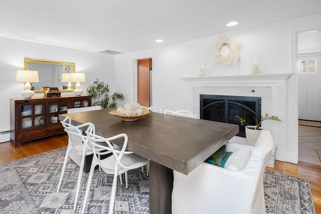 dining room featuring recessed lighting, visible vents, wood finished floors, and a fireplace