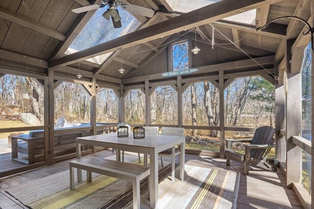 sunroom with lofted ceiling with beams and a ceiling fan