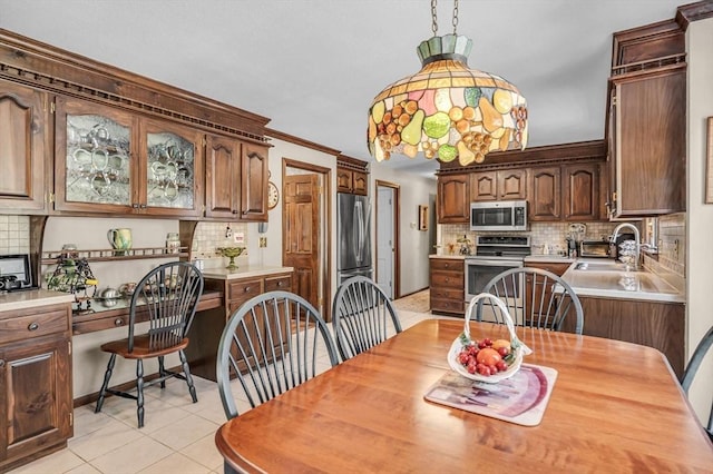 dining area with sink, light tile patterned floors, and built in desk