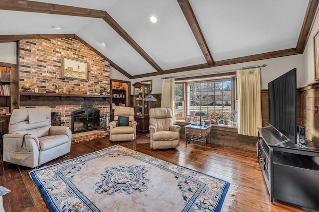 living room with lofted ceiling with beams, hardwood / wood-style flooring, and a fireplace