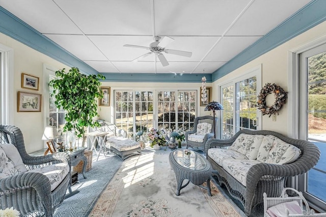 sunroom with a paneled ceiling and ceiling fan