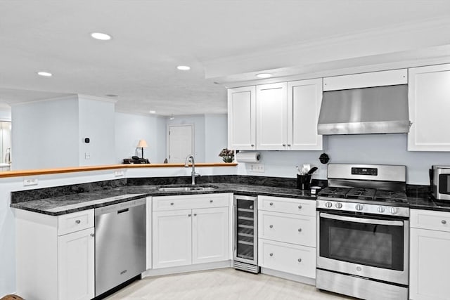 70 Humphreys Ln Unit 70, Duxbury, MA 02332 - kitchen featuring appliances with stainless steel finishes, wall chimney range hood, beverage cooler, a sink, and a peninsula