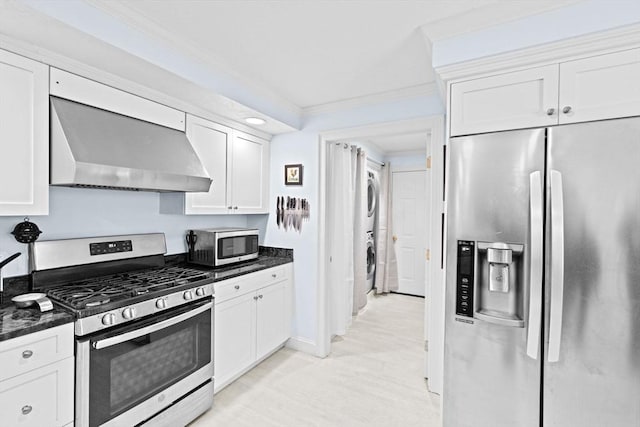 70 Humphreys Ln Unit 70, Duxbury, MA 02332 - kitchen with stainless steel appliances, stacked washer / drying machine, wall chimney exhaust hood, white cabinetry, and ornamental molding