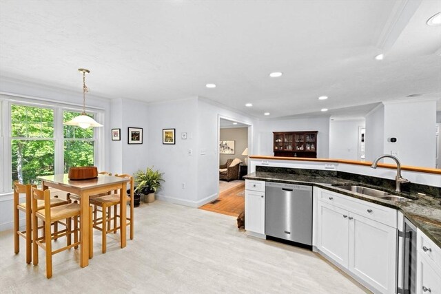 70 Humphreys Ln Unit 70, Duxbury, MA 02332 - kitchen with stainless steel dishwasher, a sink, light wood-style flooring, ornamental molding, and white cabinetry