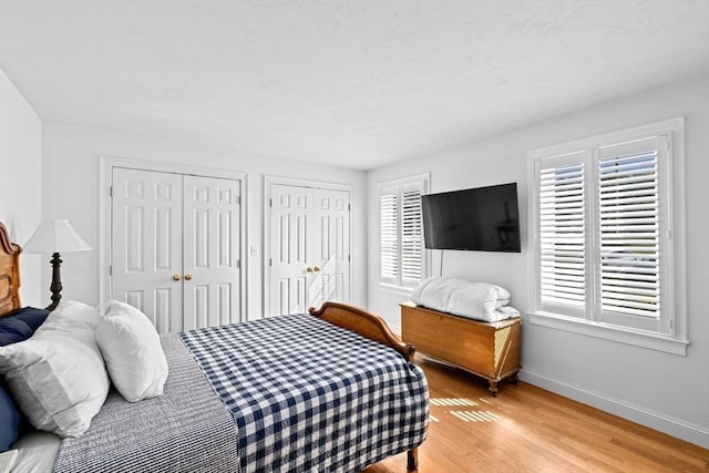 70 Humphreys Ln Unit 70, Duxbury, MA 02332 - bedroom with two closets, light wood-style flooring, and baseboards